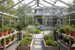 “High-resolution photo of a modern aluminum greenhouse in a landscaped backyard, interior view showing raised garden beds, potted plants, and natural light, clean architectural design, soft daylight, realistic residential setting.”
